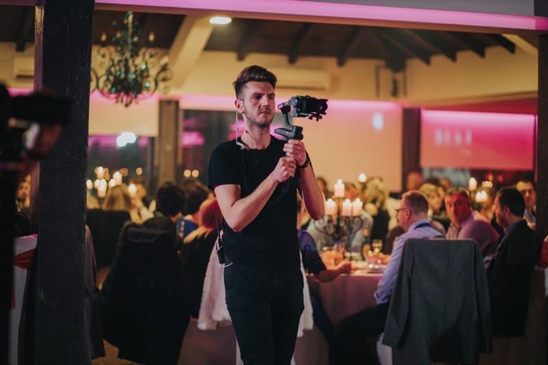 A videographer capturing moments at an elegant reception, showcasing event videography skills.