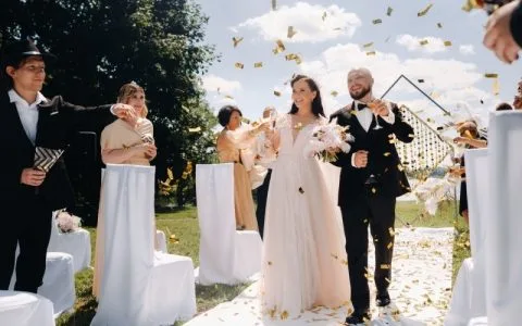 10 Pro Steps for Filmmakers: Cinematic Wedding Videos That Couples Love. A joyful bride and groom celebrate their wedding day surrounded by confetti in a beautiful outdoor setting.