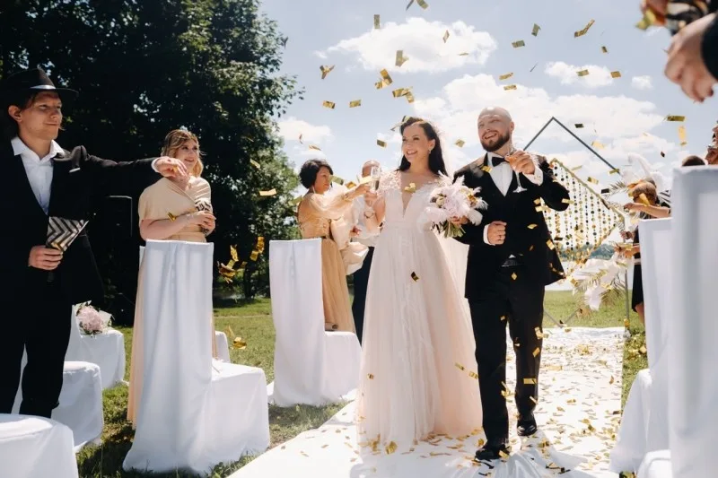 10 Pro Steps for Filmmakers: Cinematic Wedding Videos That Couples Love. A joyful bride and groom celebrate their wedding day surrounded by confetti in a beautiful outdoor setting.