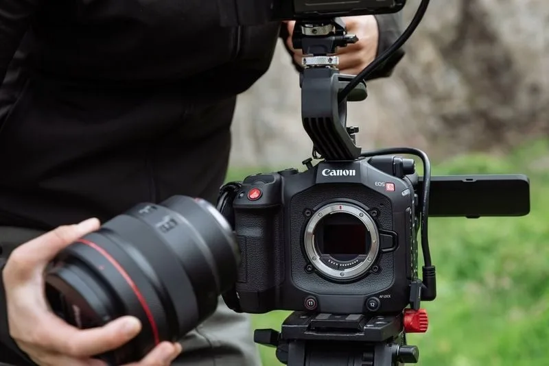 A Canon EOS camera being held in a professional setup, ready for photography.