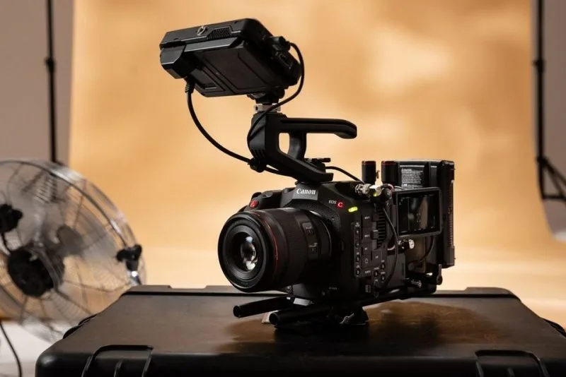 Canon EOS camera setup with a monitor and accessories, ideal for videography and filmmaking.