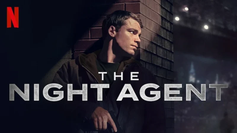 A character from 'The Night Agent' series on Netflix, with a serious expression while holding a gun in an urban setting.