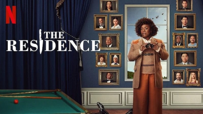 A character from the Netflix series 'The Residence' stands with binoculars in a stylish outfit, surrounded by framed portraits of the cast on a blue backdrop.