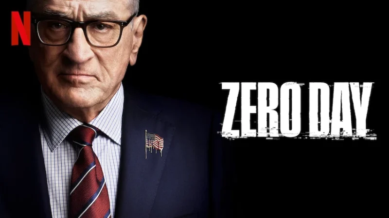 A serious-looking man in a suit, featured in the Netflix series 'Zero Day', with an American flag pin on his lapel.