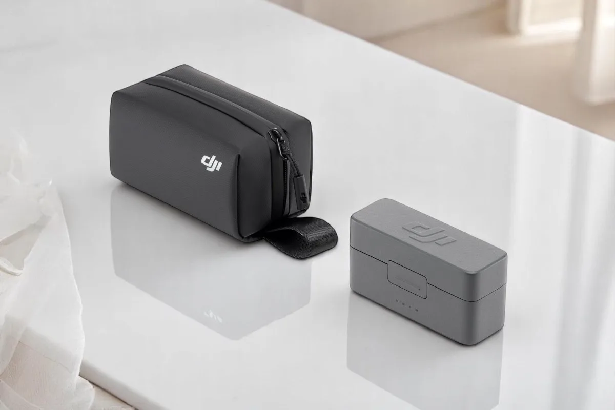 A sleek black carrying case and a grey charger from DJI, elegantly placed on a white surface.